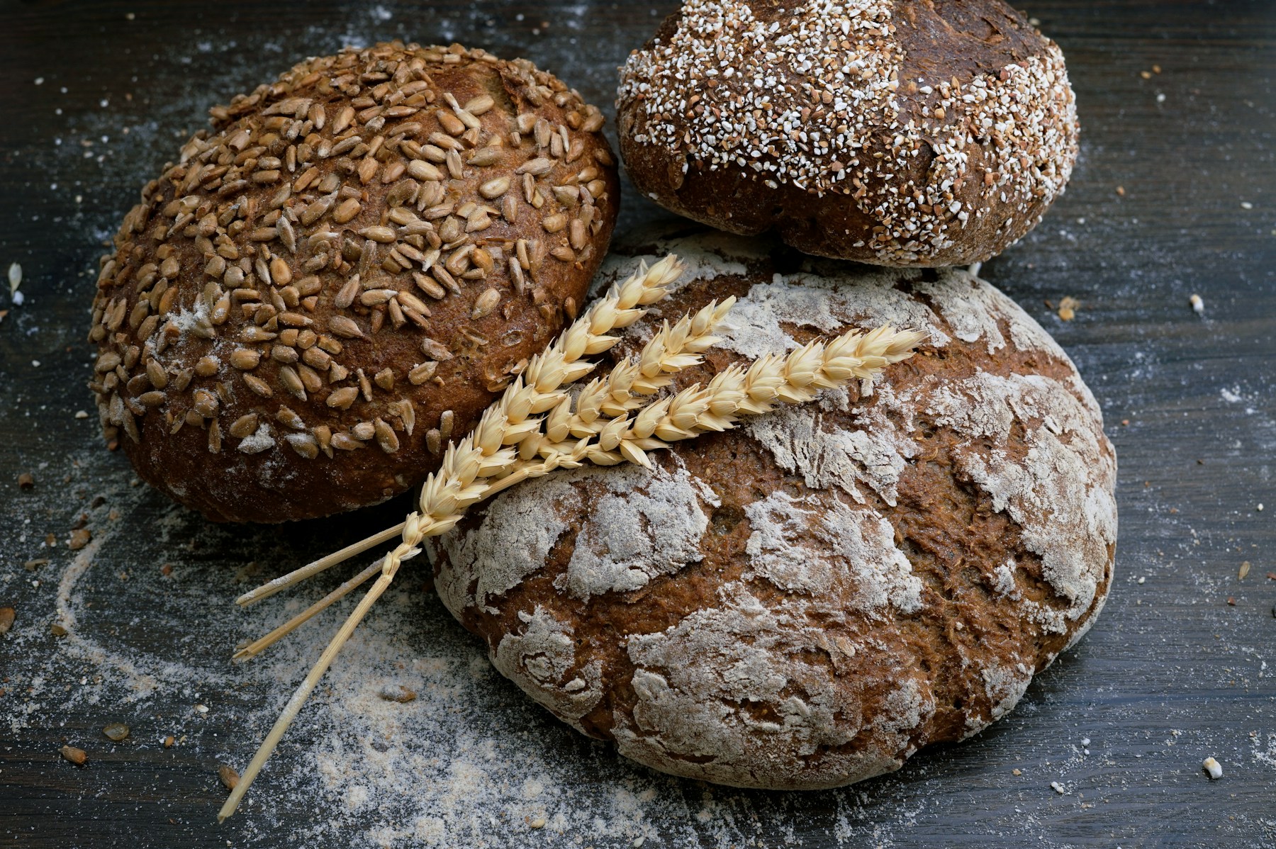 Flour-dusted and seeded bread with ears of wheat
